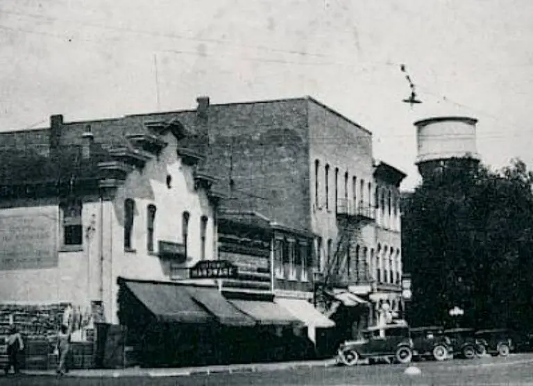 A black and white photo of a street with a water tower in Oxford, Ohio.